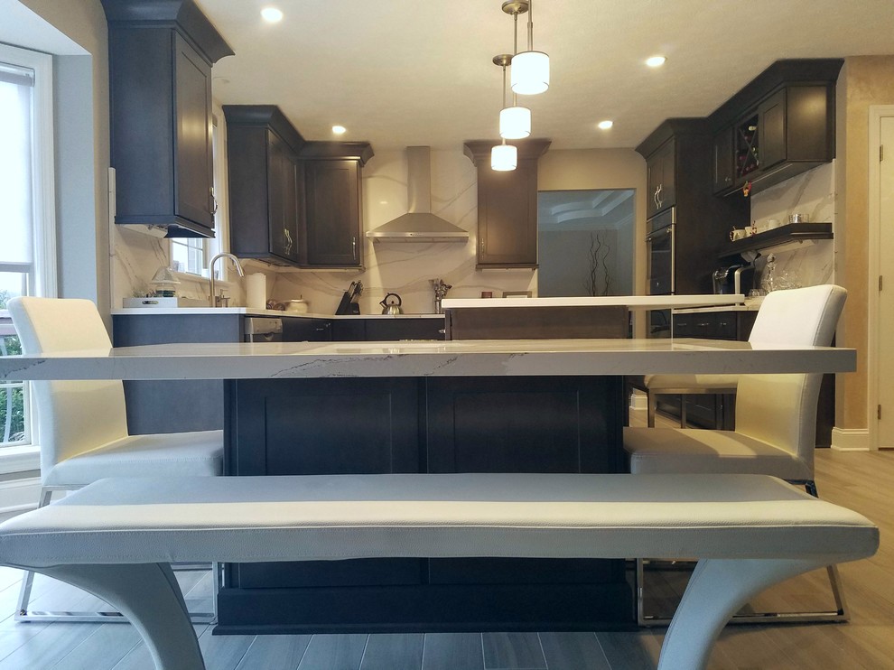 Inspiration for a mid-sized transitional l-shaped porcelain tile and gray floor enclosed kitchen remodel with an undermount sink, raised-panel cabinets, dark wood cabinets, quartz countertops, white backsplash, stone slab backsplash, stainless steel appliances and an island