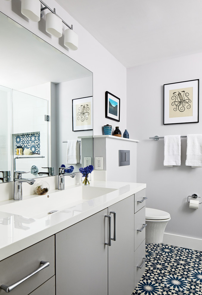 Design ideas for a mid-sized contemporary master bathroom in DC Metro with flat-panel cabinets, grey cabinets, a corner shower, a wall-mount toilet, white tile, grey walls, a hinged shower door and white benchtops.
