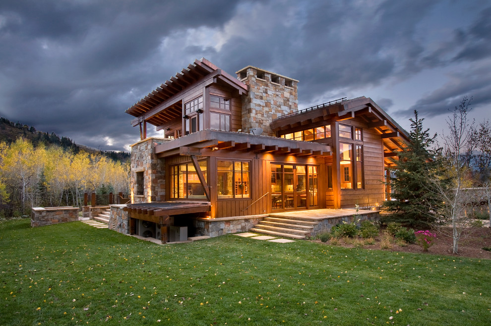 Photo of a large country two-storey beige house exterior in Denver with stone veneer.