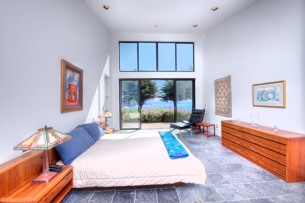 Large contemporary master bedroom in San Francisco with white walls and slate floors.