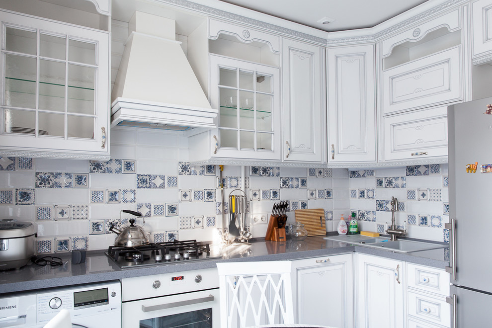 L-shaped kitchen photo in Moscow with marble countertops and white backsplash