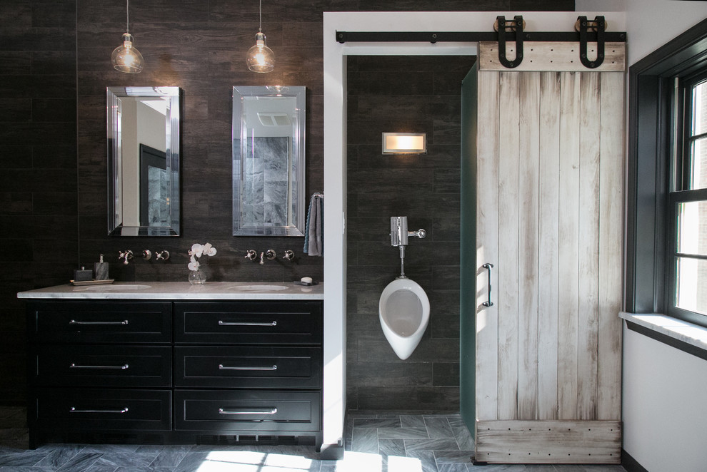 This is an example of a mid-sized eclectic master bathroom in Philadelphia with an undermount sink, recessed-panel cabinets, black cabinets, marble benchtops, a freestanding tub, a curbless shower, a wall-mount toilet, gray tile, stone tile, white walls and marble floors.
