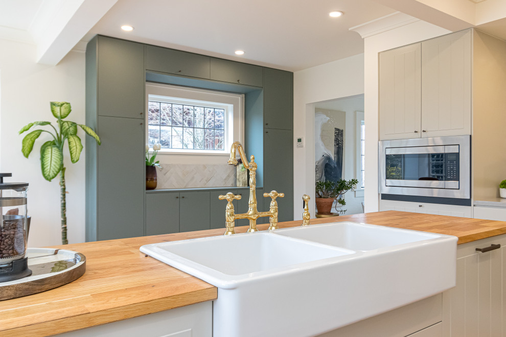 Example of a mid-sized transitional l-shaped medium tone wood floor, brown floor and coffered ceiling eat-in kitchen design with a farmhouse sink, raised-panel cabinets, gray cabinets, wood countertops, beige backsplash, ceramic backsplash, stainless steel appliances, an island and brown countertops