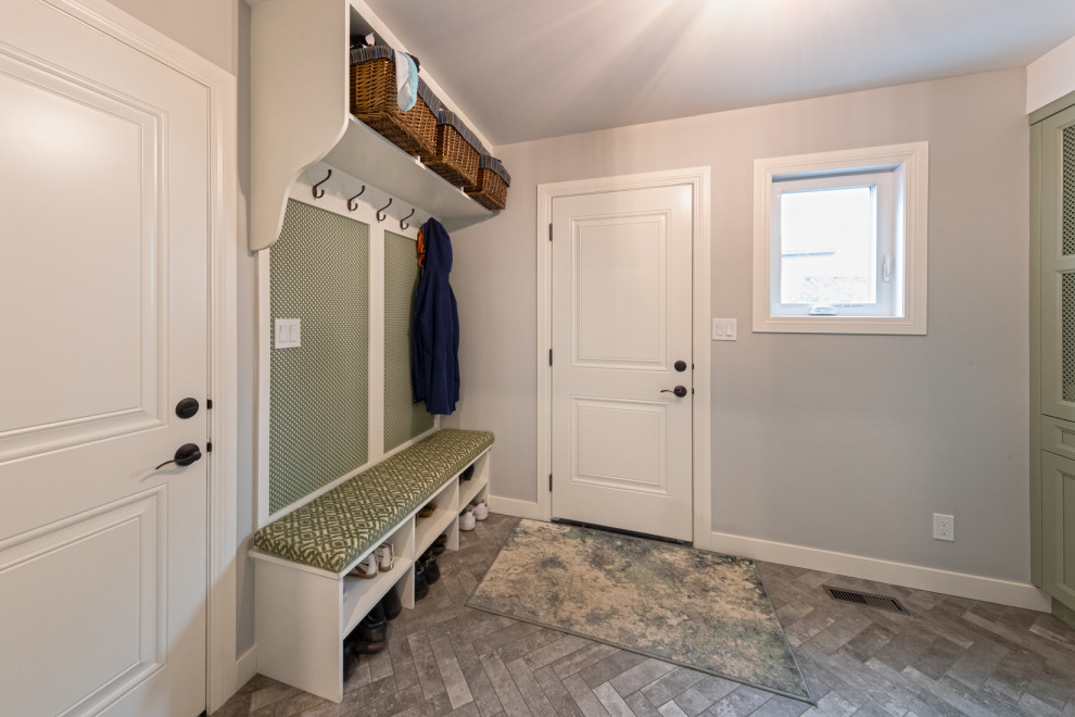 Mid-sized traditional galley dedicated laundry room in Edmonton with a single-bowl sink, recessed-panel cabinets, green cabinets, quartz benchtops, grey splashback, ceramic splashback, grey walls, ceramic floors, a stacked washer and dryer, multi-coloured floor and multi-coloured benchtop.