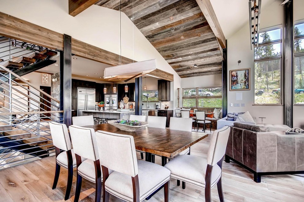 Inspiration for a large rustic light wood floor and brown floor great room remodel in Denver with beige walls and no fireplace