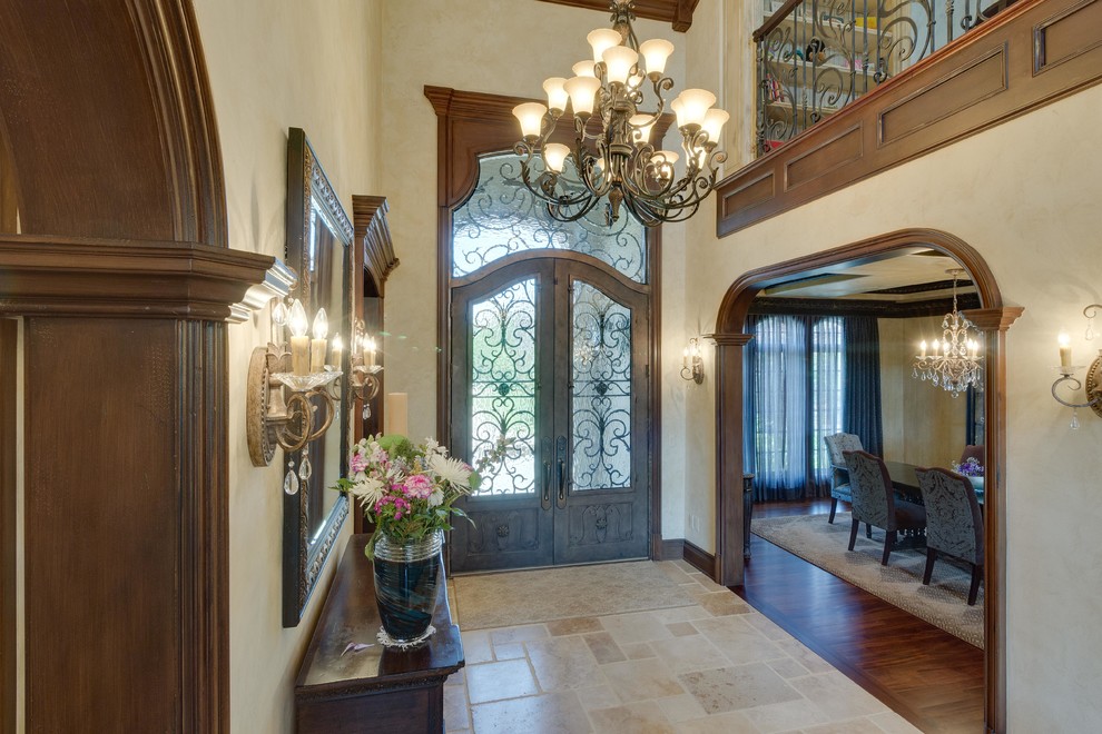 Inspiration for a large traditional foyer in Detroit with beige walls, travertine floors, a double front door, a dark wood front door and beige floor.