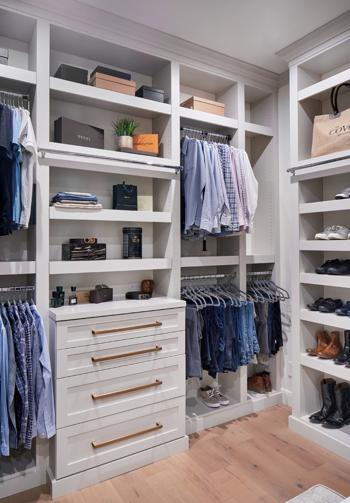 This is an example of a large transitional gender-neutral walk-in wardrobe in Austin with shaker cabinets, grey cabinets, light hardwood floors and grey floor.