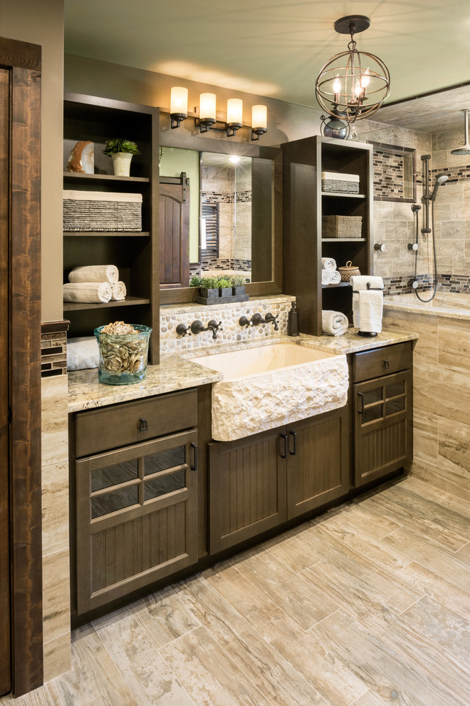 Inspiration for a large rustic master brown tile and porcelain tile porcelain tile doorless shower remodel in Providence with beaded inset cabinets, dark wood cabinets, a two-piece toilet, green walls, a trough sink and granite countertops