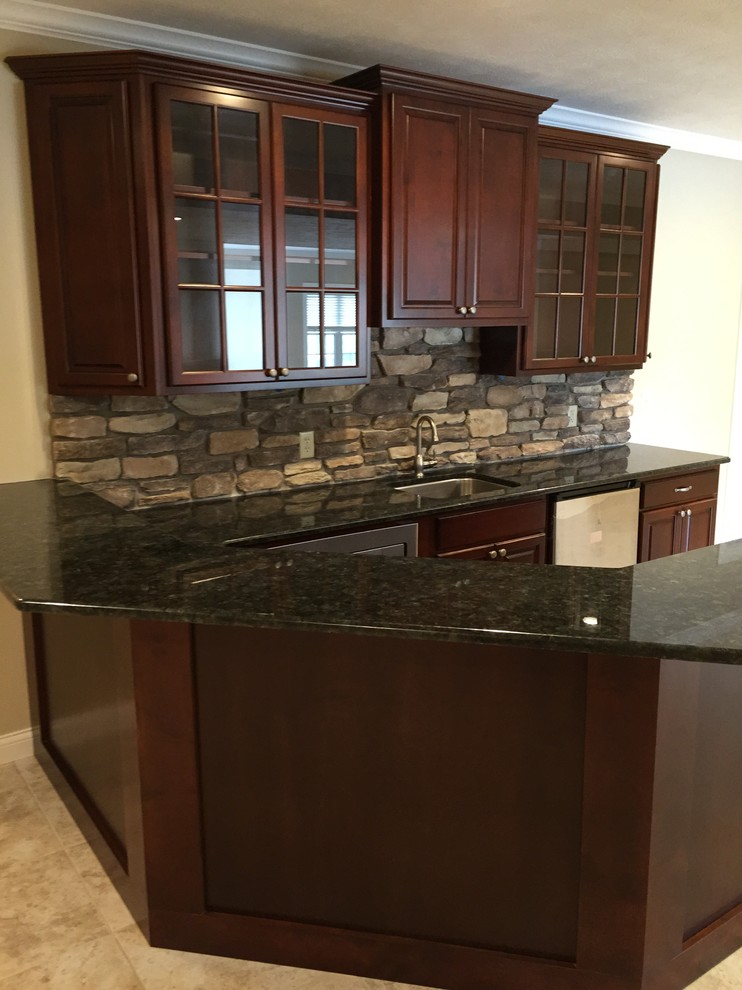 This is an example of a mid-sized traditional u-shaped wet bar in Other with an undermount sink, raised-panel cabinets, dark wood cabinets, quartzite benchtops, multi-coloured splashback, subway tile splashback and ceramic floors.