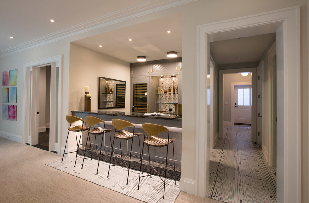 Mid-sized transitional single-wall seated home bar in New York with beaded inset cabinets, grey cabinets, onyx benchtops, grey splashback, stone tile splashback and carpet.