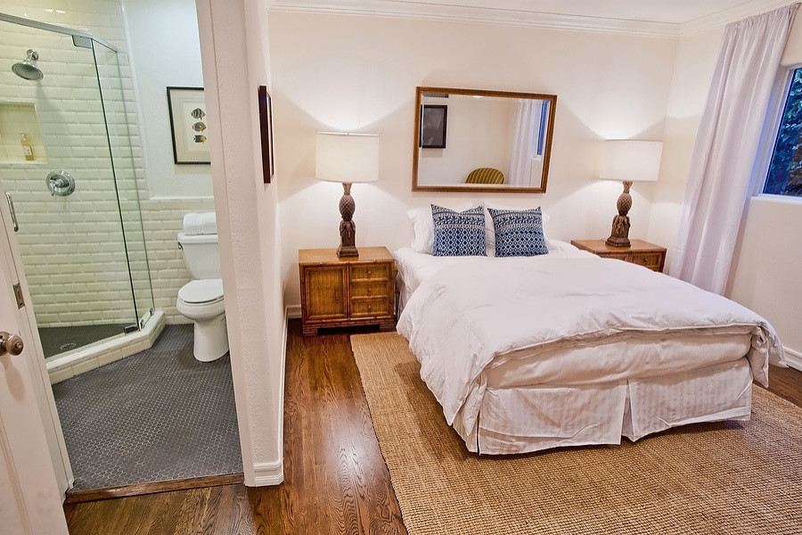 Design ideas for a transitional bedroom in Los Angeles with white walls, dark hardwood floors and brown floor.