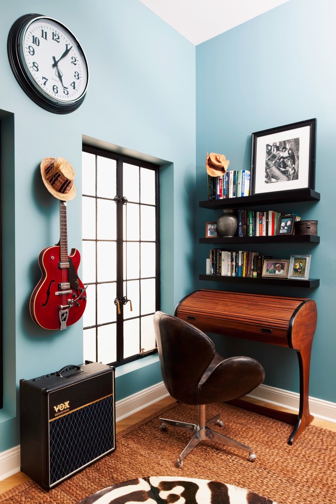 This is an example of an eclectic home office in New York with blue walls and a freestanding desk.