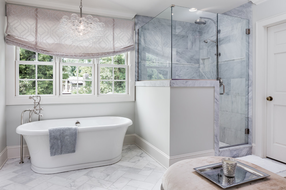 Photo of a large transitional master bathroom in Nashville with a freestanding tub, a corner shower, gray tile, marble, grey walls, marble floors, grey floor and a hinged shower door.