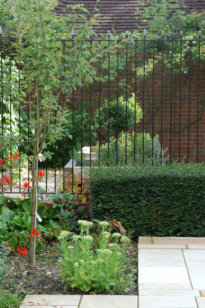 Photo of a contemporary front garden in London with a vegetable patch and natural stone paving.