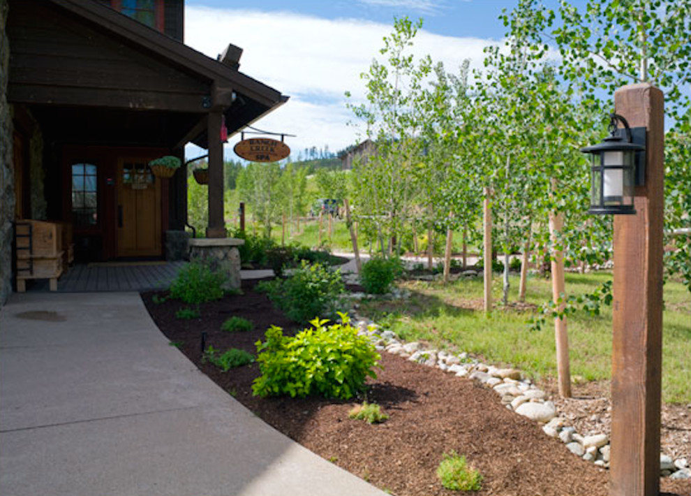 Photo of a mid-sized rustic full sun backyard stone landscaping in Denver for summer.