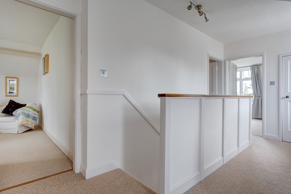 This is an example of a mid-sized contemporary hallway in Devon with white walls and carpet.