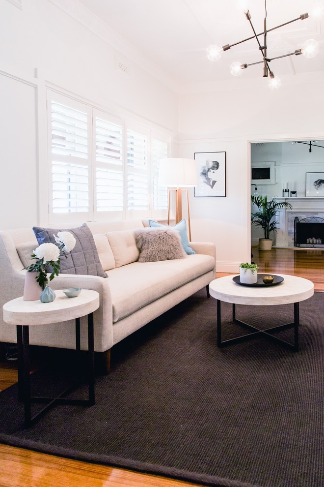 Photo of a large scandinavian living room in Melbourne with white walls and medium hardwood floors.