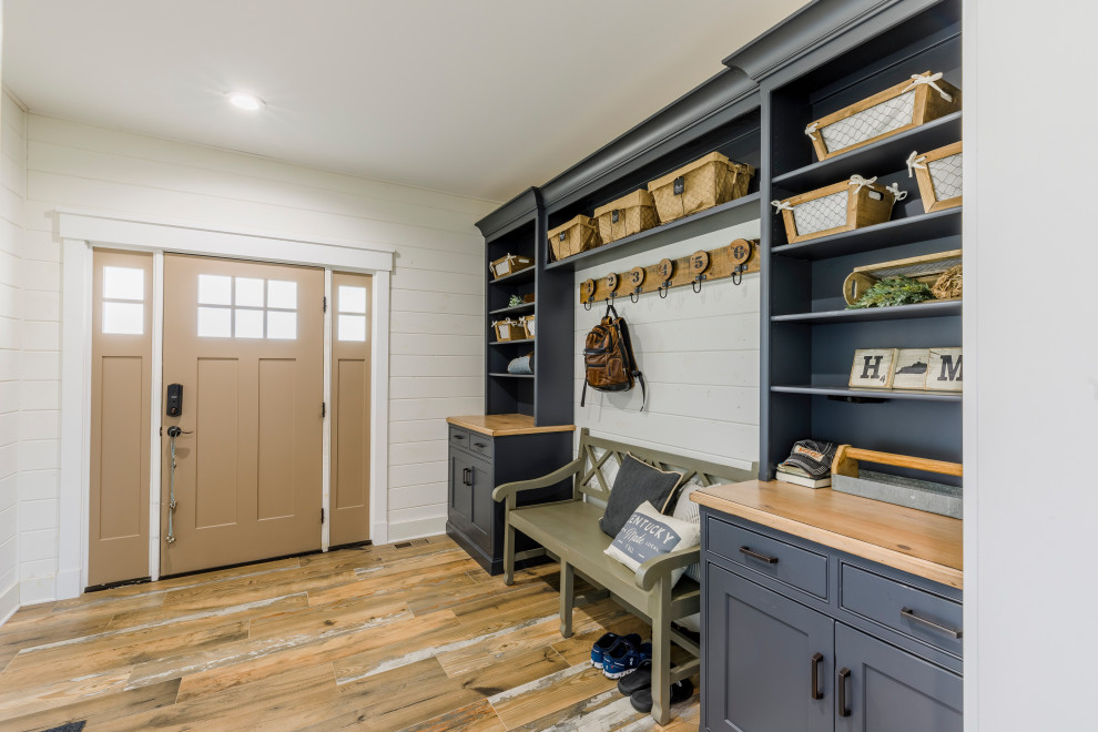 Photo of a large country mudroom in Louisville with white walls, ceramic floors, a single front door, a brown front door and planked wall panelling.