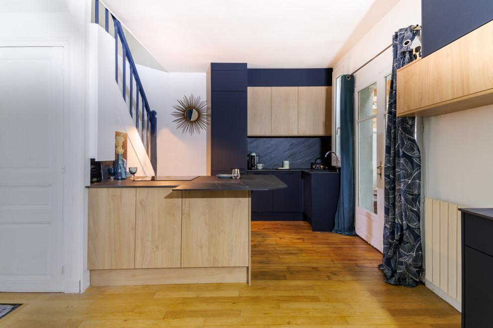 Идея дизайна: кухня в современном стиле с светлыми деревянными фасадами, серым фартуком и серой столешницей