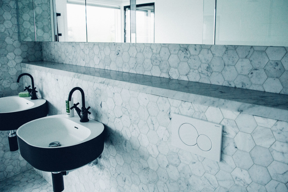Photo of a contemporary bathroom in Sydney with marble benchtops, raised-panel cabinets, black and white tile and stone slab.