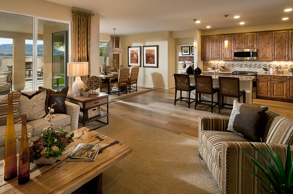 Inspiration for a large transitional l-shaped light wood floor and brown floor open concept kitchen remodel in Phoenix with an undermount sink, raised-panel cabinets, medium tone wood cabinets, granite countertops, beige backsplash, ceramic backsplash, stainless steel appliances and an island