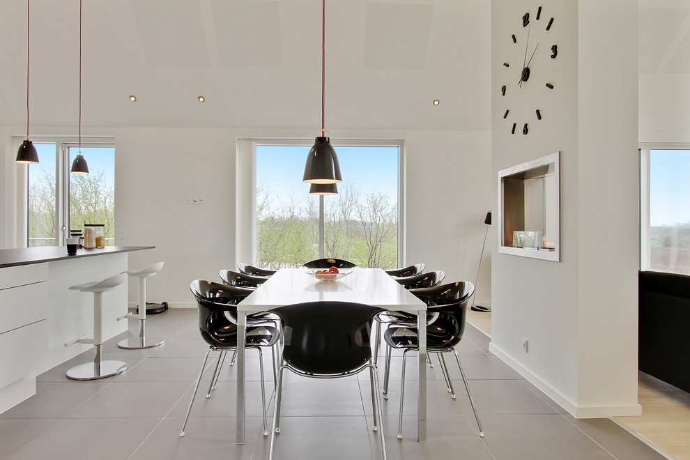 This is an example of a large scandinavian dining room in Aarhus with white walls and grey floor.