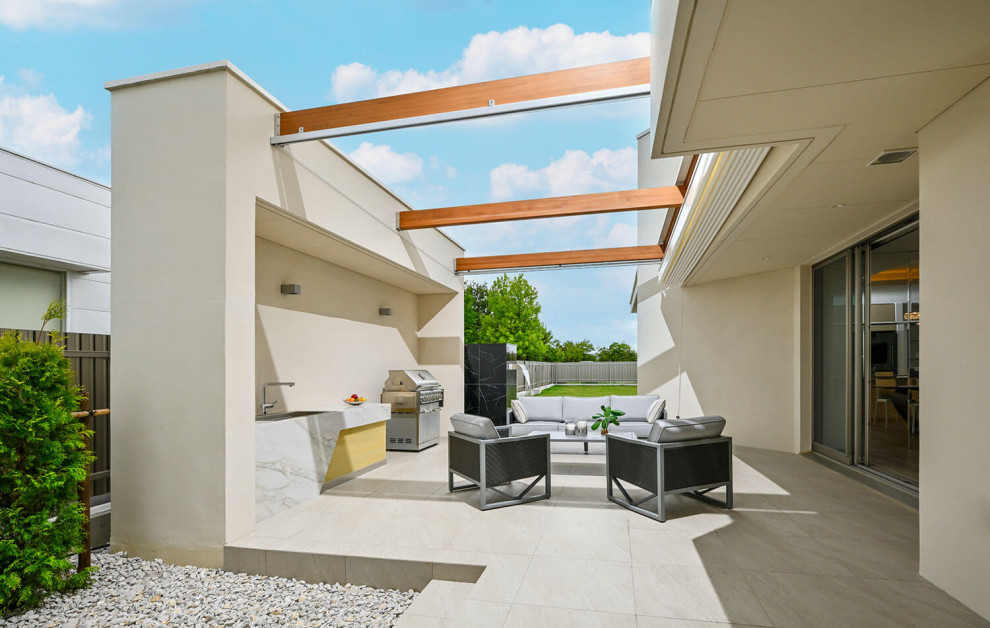 Exemple d'une terrasse latérale moderne de taille moyenne avec un point d'eau et du carrelage.