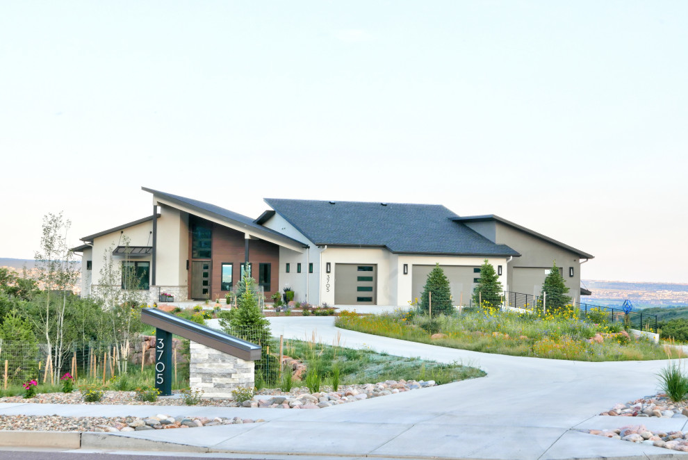 Large contemporary front yard full sun xeriscape in Denver with river rock for summer.