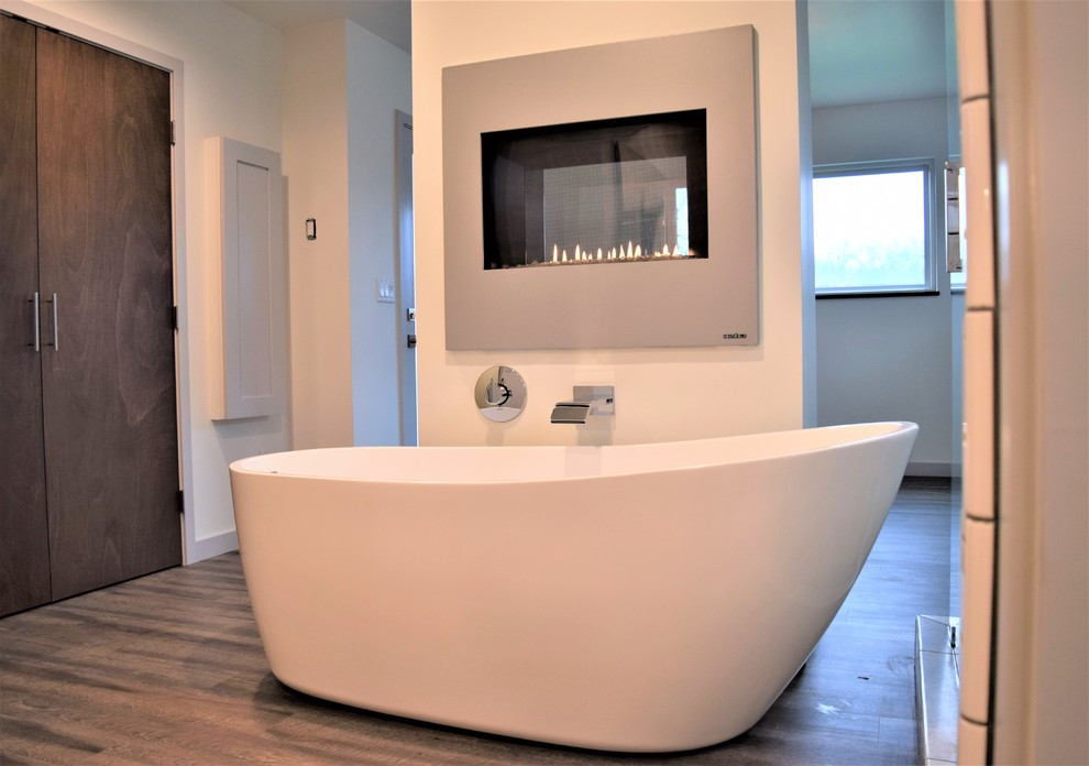 This is an example of a mid-sized modern master bathroom with shaker cabinets, grey cabinets, a freestanding tub, a corner shower, a one-piece toilet, white tile, ceramic tile, white walls, linoleum floors, an undermount sink, marble benchtops, brown floor and a hinged shower door.