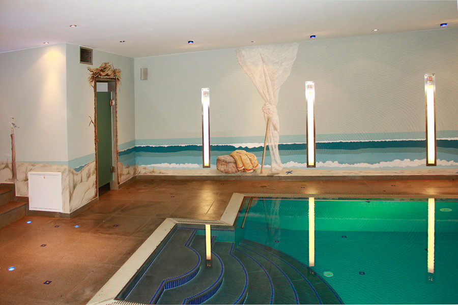 Ejemplo de piscina marinera grande interior y rectangular con adoquines de piedra natural