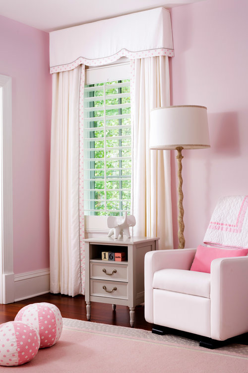 Photo of a mid-sized traditional nursery for girls in DC Metro with pink walls and dark hardwood floors.