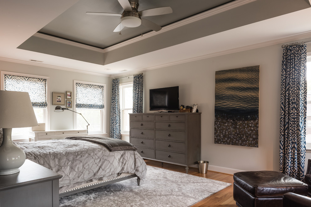 Inspiration for a large traditional master bedroom in St Louis with light hardwood floors, brown floor and grey walls.