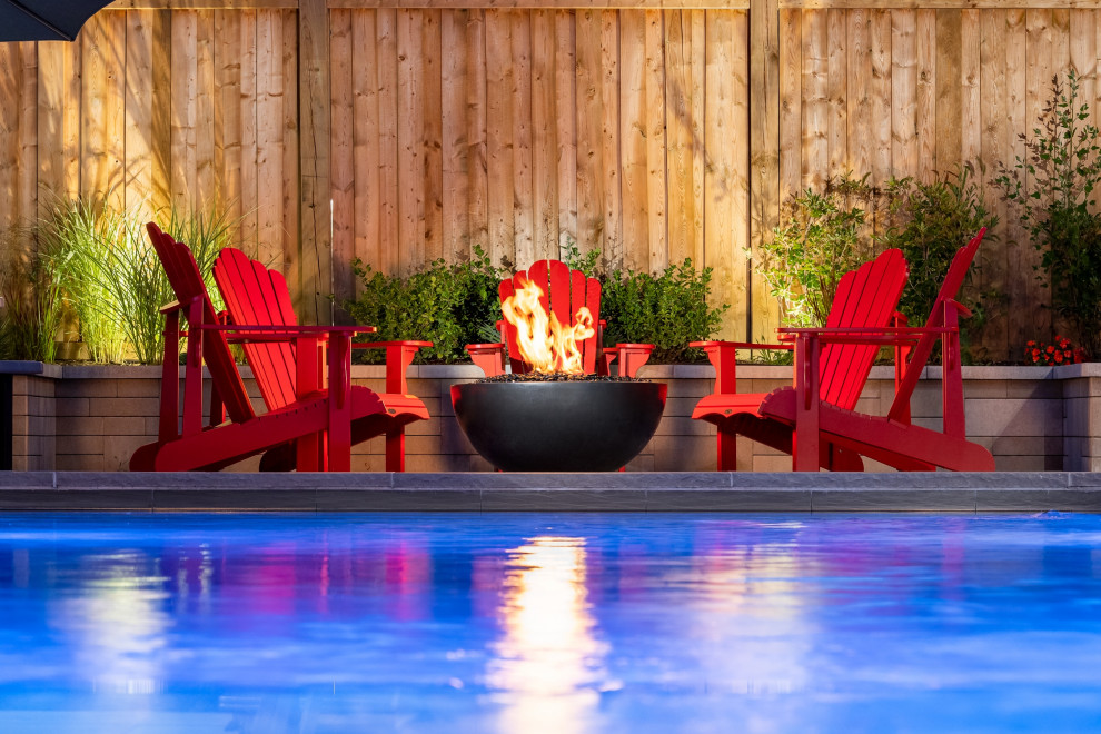 Inspiration for a mid-sized transitional backyard concrete paver and rectangular infinity pool landscaping remodel in Toronto
