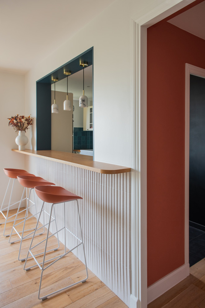 Design ideas for a large modern seated home bar in Paris with wood benchtops, blue splashback, ceramic splashback, light hardwood floors and orange benchtop.