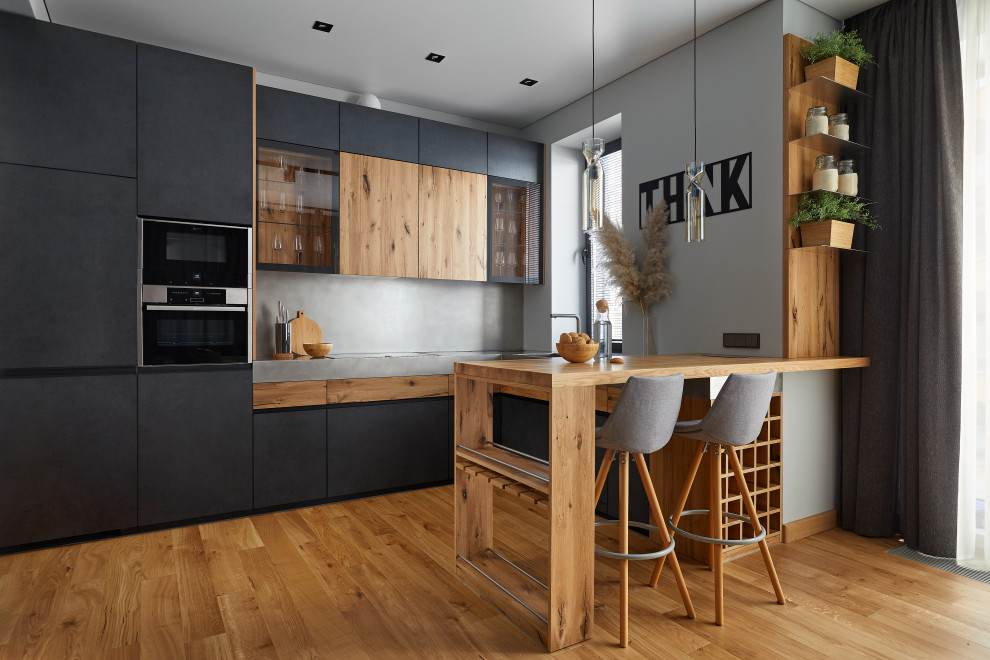 Mid-sized u-shaped eat-in kitchen in Moscow with a single-bowl sink, brown cabinets, stainless steel benchtops, grey splashback, panelled appliances, with island and grey benchtop.