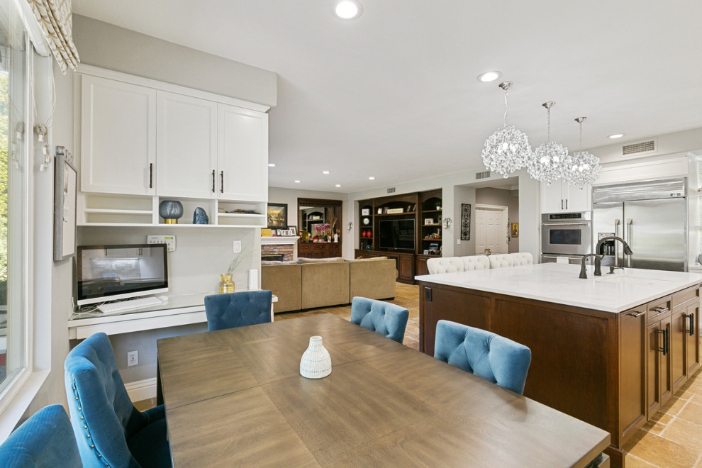 Huge transitional u-shaped travertine floor and beige floor open concept kitchen photo in Orange County with a single-bowl sink, shaker cabinets, white cabinets, quartz countertops, multicolored backsplash, stone tile backsplash, stainless steel appliances, an island and white countertops