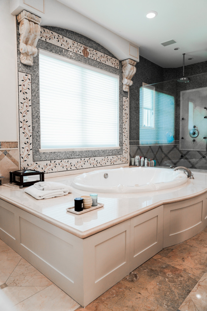 Esempio di una stanza da bagno padronale tradizionale con ante con bugna sagomata e vasca da incasso