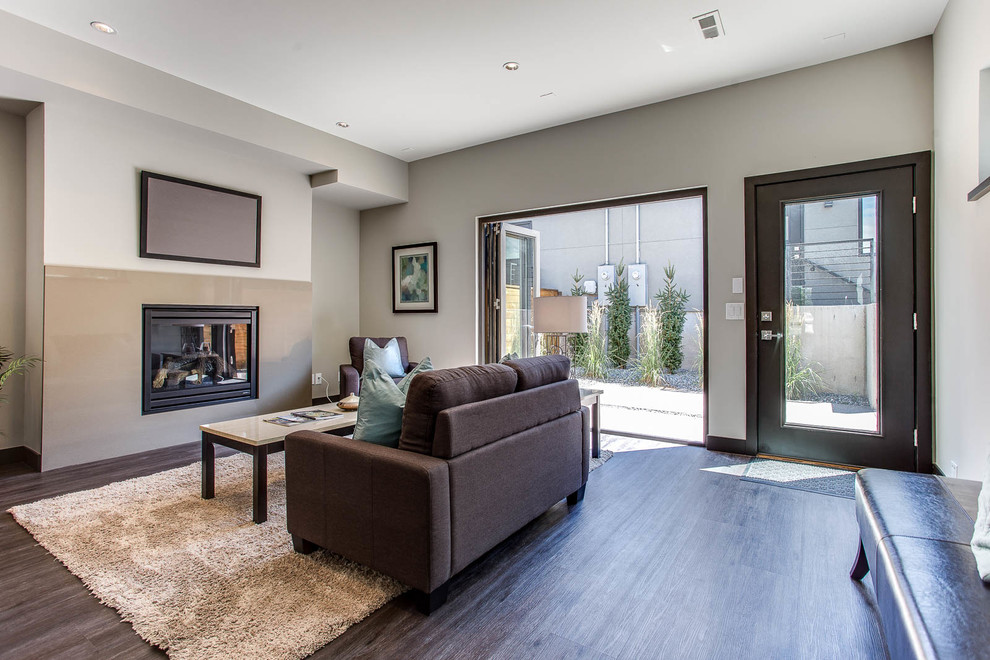 Small contemporary formal enclosed living room in Denver with beige walls, dark hardwood floors, a standard fireplace, a metal fireplace surround and a wall-mounted tv.