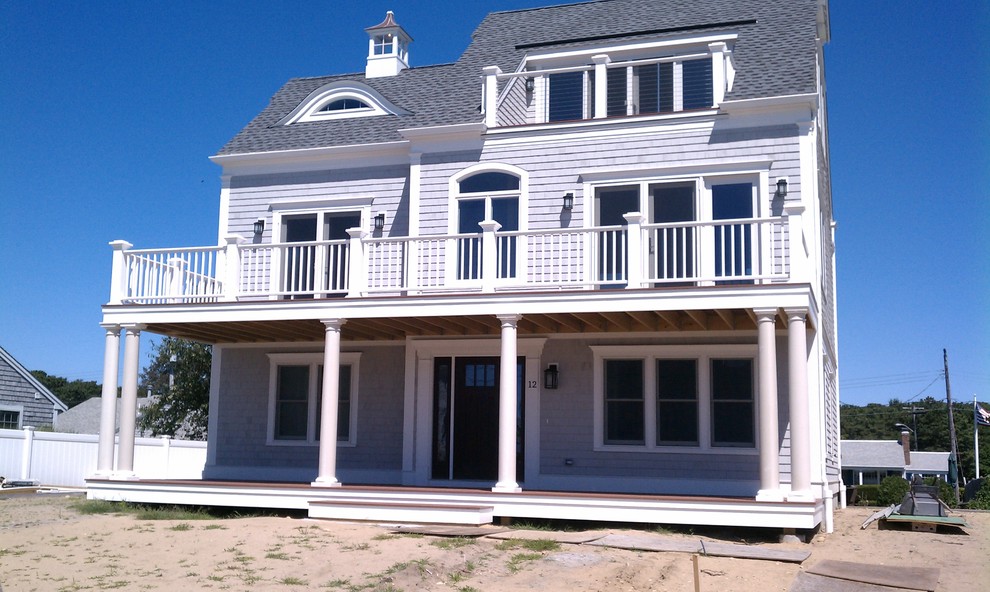 Mid-sized beach style two-storey grey house exterior in Boston with wood siding, a gable roof and a shingle roof.