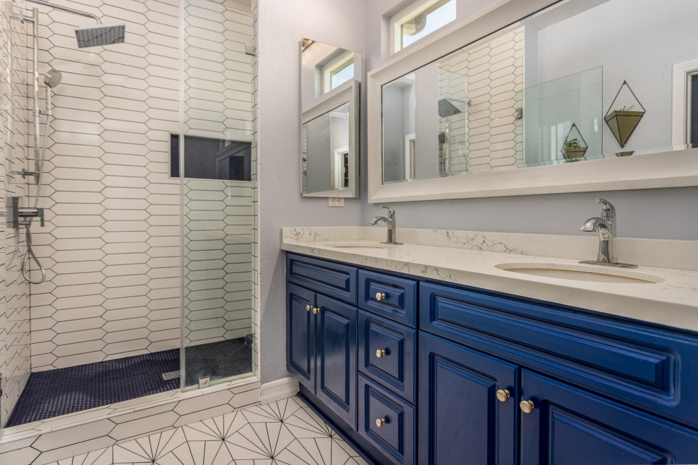 Photo of a mid-sized contemporary master bathroom in San Diego with shaker cabinets, blue cabinets, a corner shower, white tile, porcelain tile, blue walls, porcelain floors, an undermount sink, engineered quartz benchtops, white floor, a hinged shower door, grey benchtops, a niche, a double vanity and a built-in vanity.
