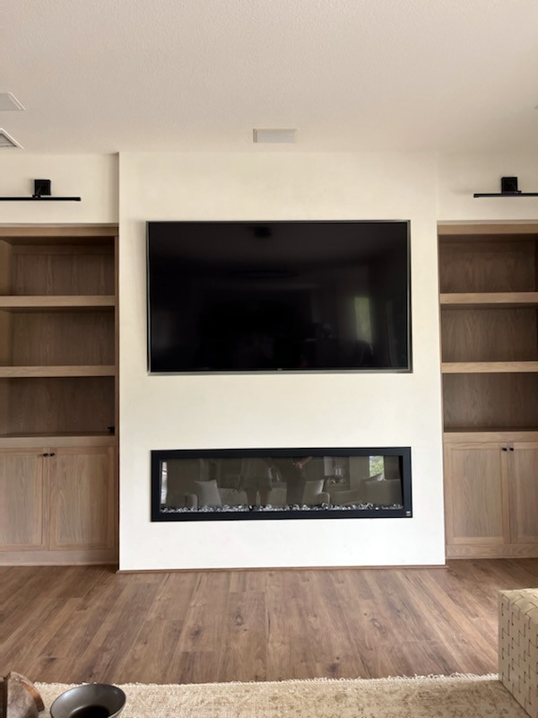 Photo of a modern family room in San Diego with a plaster fireplace surround and a ribbon fireplace.