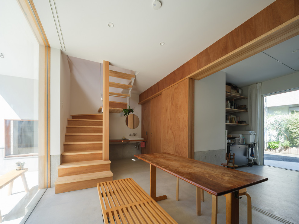 Photo of a mid-sized modern home studio in Tokyo with white walls, concrete floors, a built-in desk, white floor, timber and planked wall panelling.