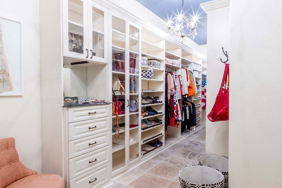 Photo of a mid-sized transitional walk-in wardrobe in Los Angeles with white cabinets, terra-cotta floors and raised-panel cabinets.