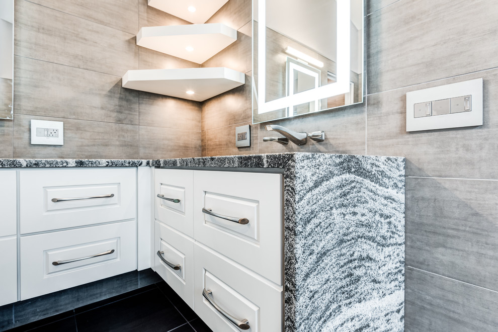 This is an example of a large modern master bathroom in Chicago with raised-panel cabinets, white cabinets, a freestanding tub, an open shower, a wall-mount toilet, gray tile, ceramic tile, grey walls, ceramic floors, an undermount sink, quartzite benchtops, grey floor and a hinged shower door.
