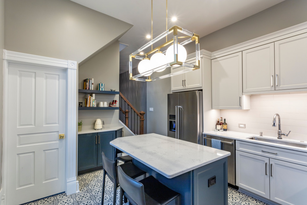 Inspiration for a transitional porcelain tile kitchen remodel with white backsplash, ceramic backsplash, stainless steel appliances, an island and white countertops