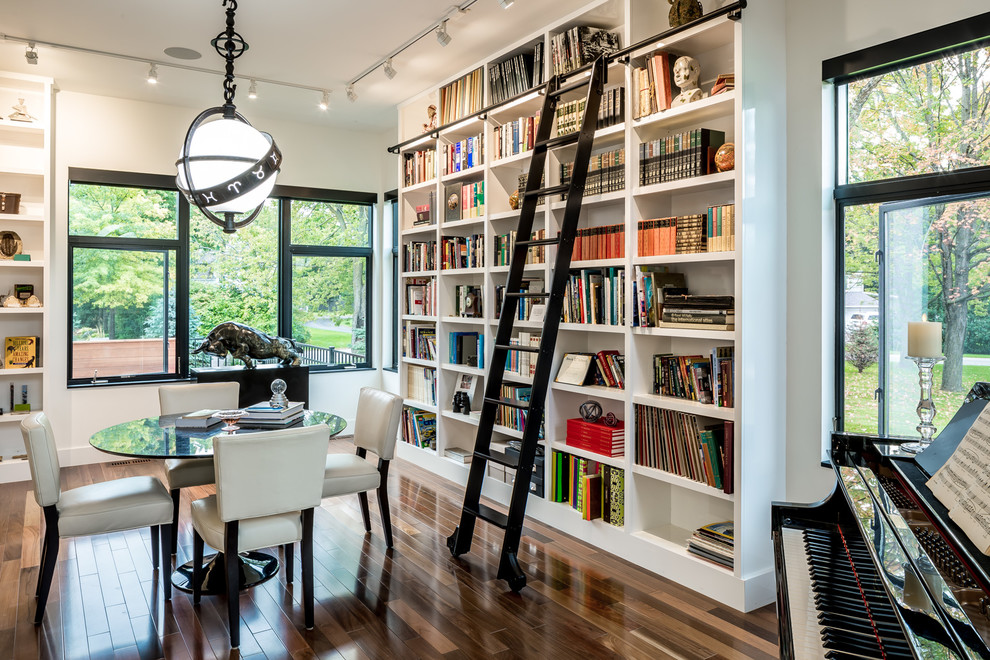 Inspiration for a large contemporary open concept family room in Minneapolis with a library, white walls, medium hardwood floors, no fireplace and no tv.