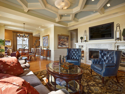 This is an example of a large traditional formal open concept living room in Philadelphia with yellow walls, light hardwood floors, a standard fireplace, a stone fireplace surround and a built-in media wall.