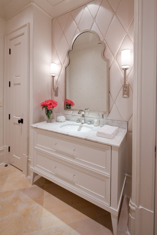 Inspiration for a small transitional beige tile powder room remodel in Atlanta with an undermount sink, recessed-panel cabinets, white cabinets, marble countertops and white walls