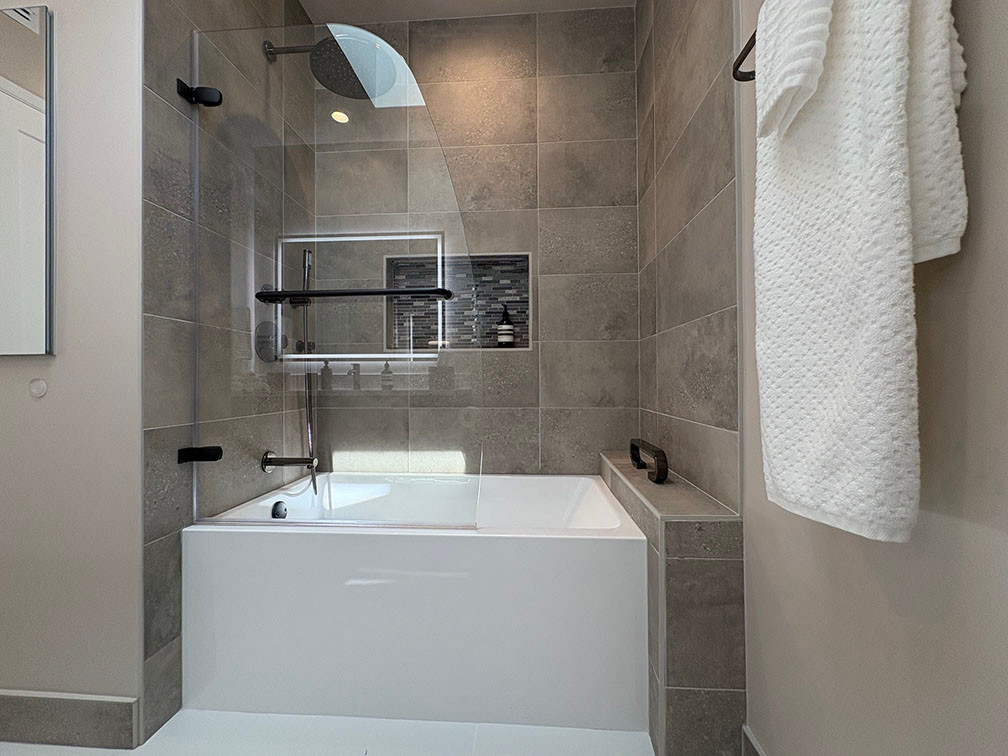 Using a soaking tub (54" wide) the homeowners can now take a long relaxing bath. We installed a grab bar on the pony wall to the right for easy in- and out. The LED-lit niche allows for a good amount