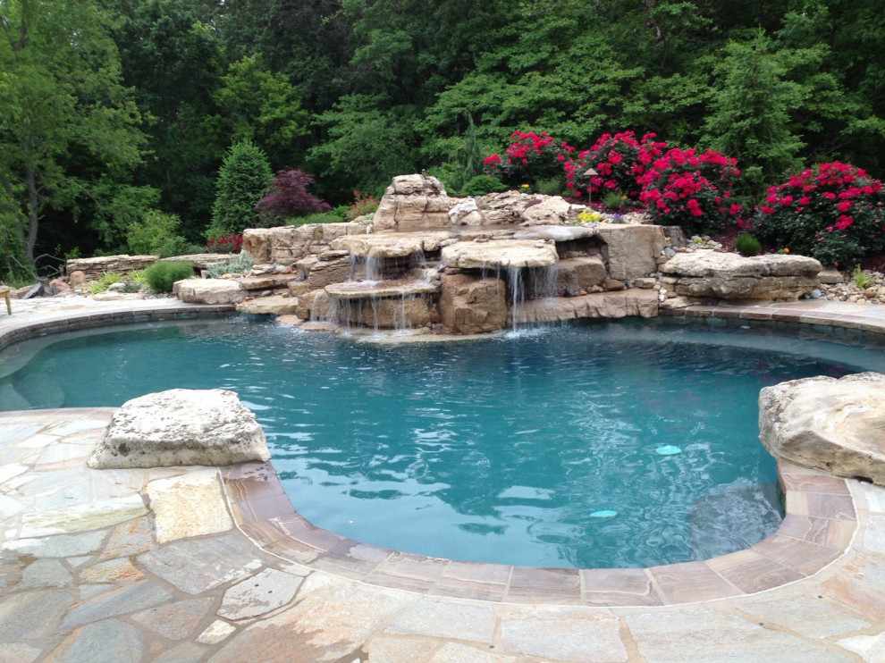 Example of a large mountain style two-story stone red pool design in St Louis